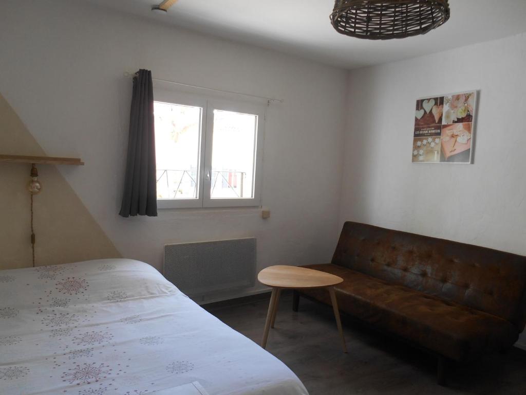 a bedroom with a bed and a couch and a window at Entre Saint-Tropez et les gorges du Verdon. in Lorgues