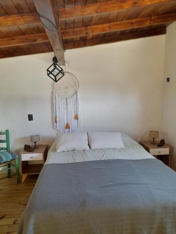 um quarto com uma cama num quarto com tectos em madeira em Casuarinas em La Estafeta