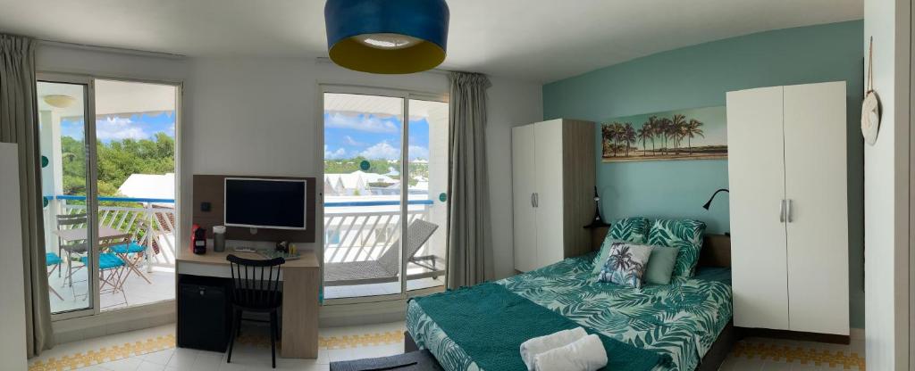 une chambre avec un lit et un bureau avec un ordinateur dans l'établissement GRAND TI-BOU Gwada breizh, à Saint-François