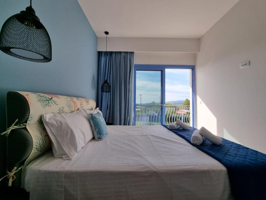 a bedroom with a large bed with a large window at Julietta Suites in Argostoli