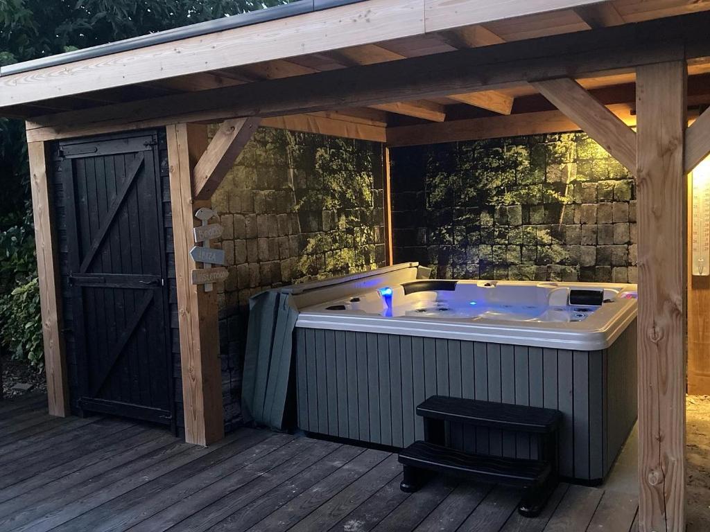 eine Whirlpool-Badewanne auf einer Holzterrasse in der Unterkunft Rue Haute by M&M 4 sterren bed en breakfast vlakbij Maastricht in Eben-Emael