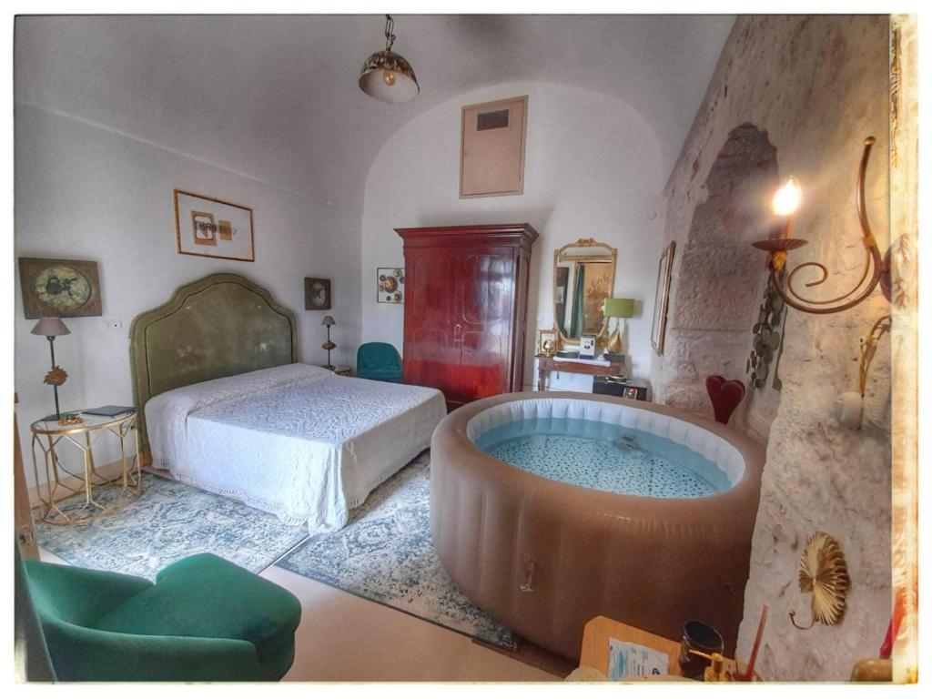 ein Schlafzimmer mit einem Bett und einer großen Badewanne in der Unterkunft B&B Luxury Villa Olimpia Home Restaurant in Selva di Fasano