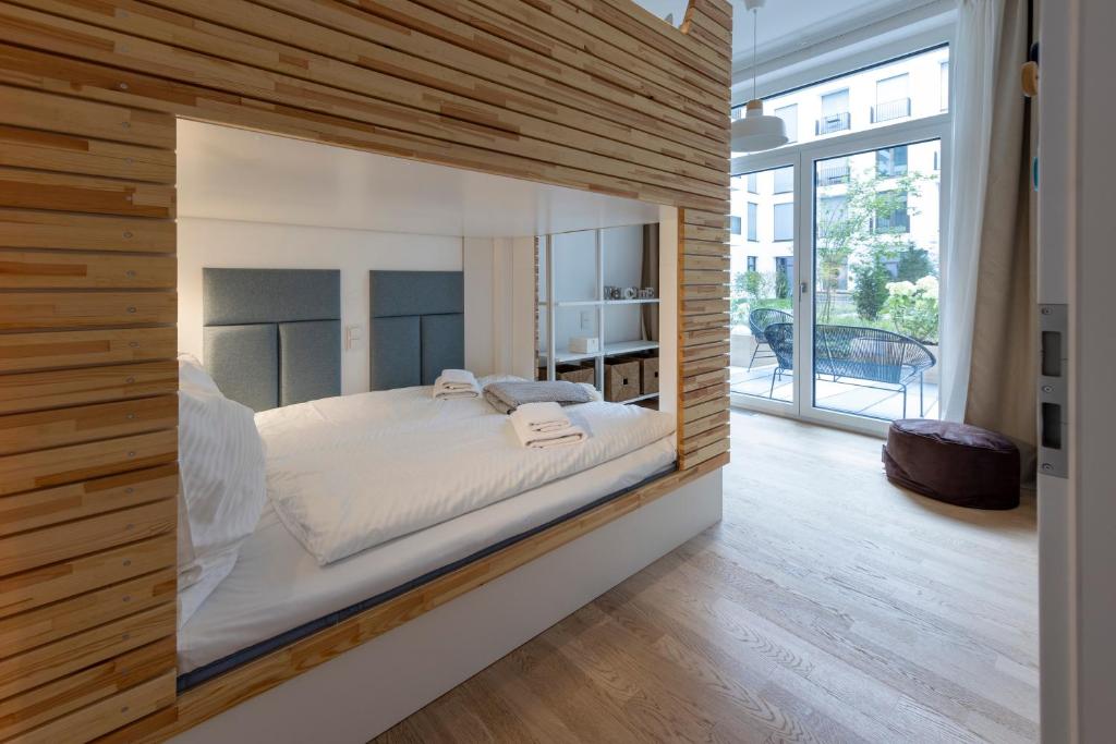 1 dormitorio con 1 cama en una habitación con paredes de madera en Pure Berlin Apartments - Luxury at Pure Living in City Center, en Berlín
