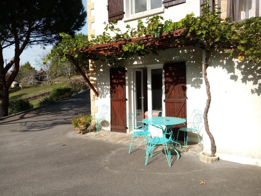 una mesa y sillas sentadas fuera de una casa en Chambre calme en correze, en Sainte-Fortunade