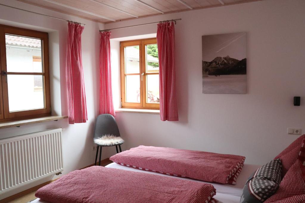 1 dormitorio con 2 camas y 2 ventanas en Ferienhaus Pfeiffer, en Schwangau