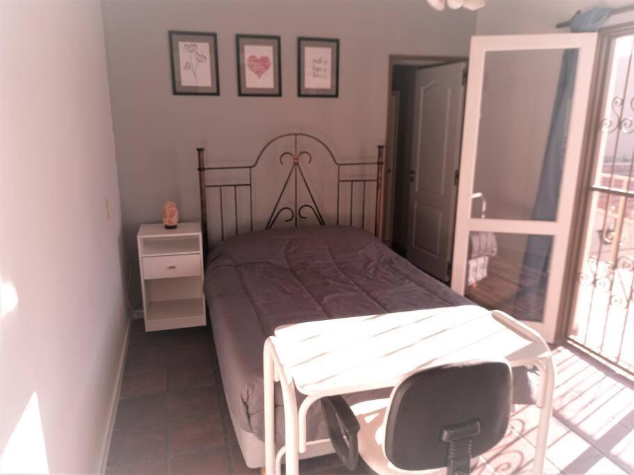 a bedroom with a bed and a table and a window at Departamento 1º P, 2 personas, WIFI, confortable, mucha luz natural in Godoy Cruz