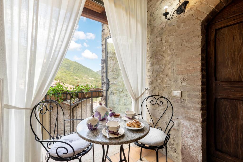 stół i krzesła na balkonie z oknem w obiekcie Torre Del Nera Albergo diffuso & Spa w mieście Scheggino