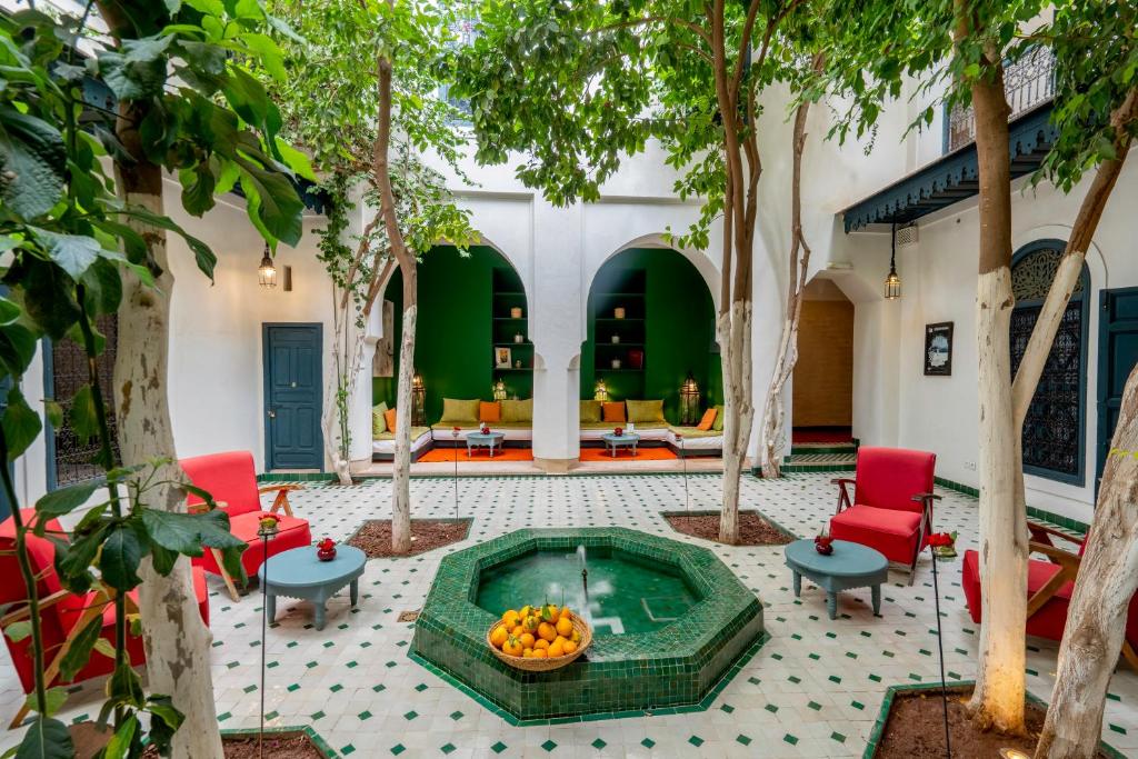 un patio con piscina, sillas y árboles en Hotel & Spa Dar Sara, en Marrakech
