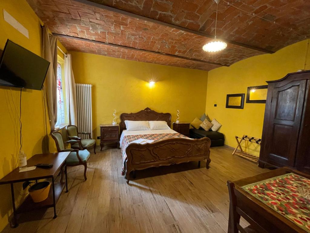 1 dormitorio con cama, sofá y mesa en Le camere del Tiglio, en Treiso