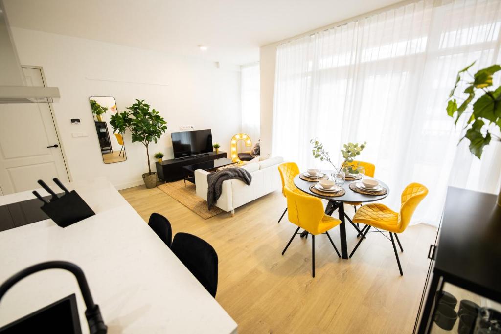 sala de estar con mesa y sillas amarillas en Cheerfully 1 Bedroom Serviced Apartment 52m2 -NB306C-, en Róterdam