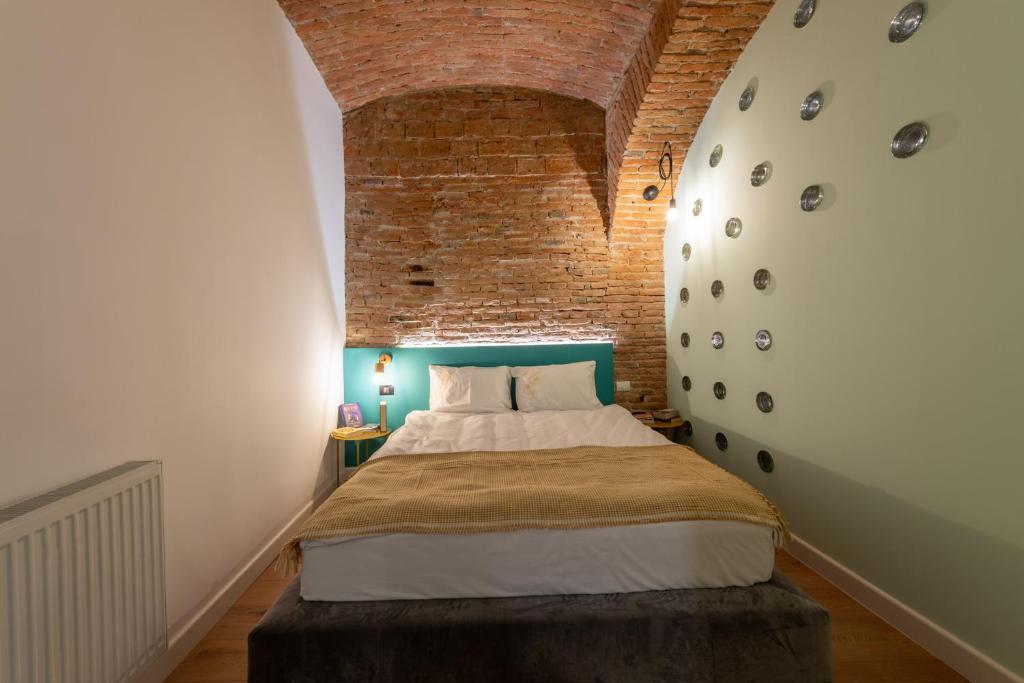 a bedroom with a bed and a brick wall at Apollo Brașovul Istoric in Braşov