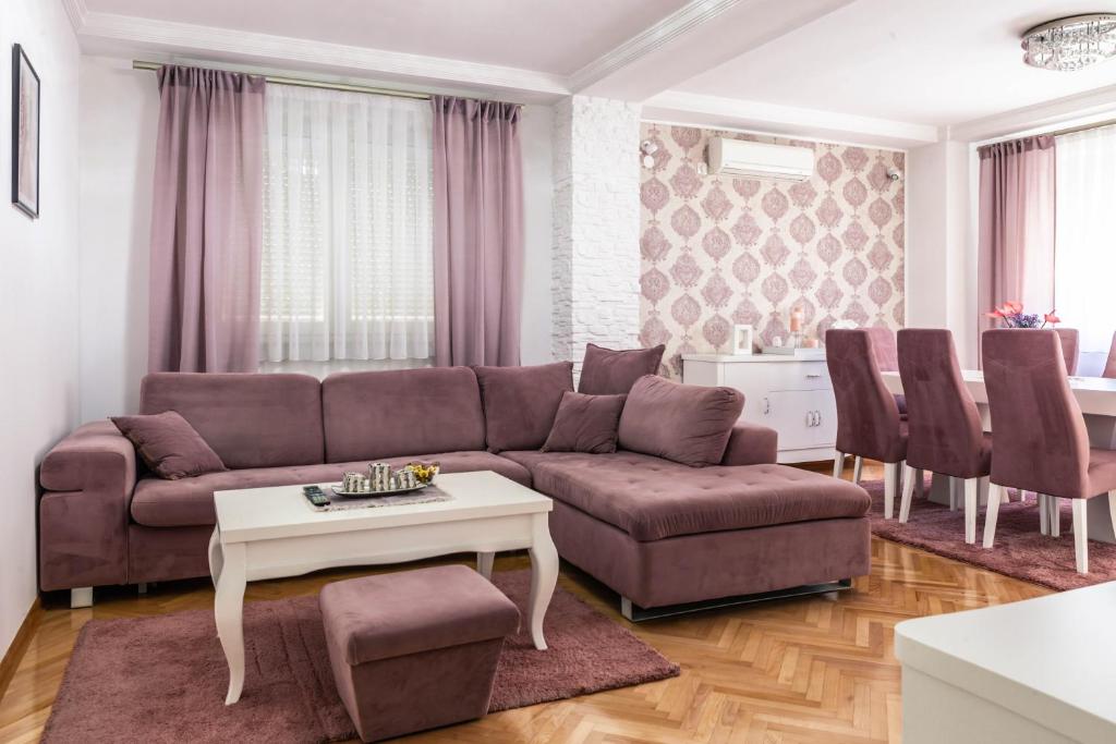 ein Wohnzimmer mit einem Sofa und einem Tisch in der Unterkunft Apartman Jana in Bijeljina