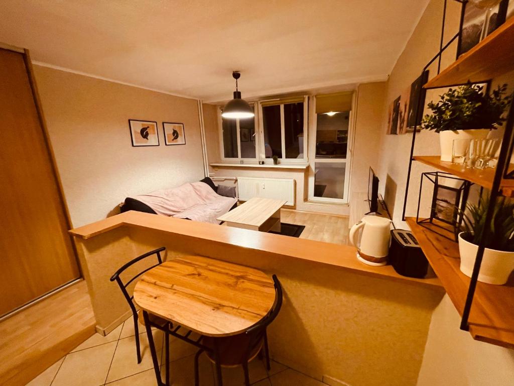 een kleine woonkamer met een tafel en een bank bij Apartamenty KTW Park Śląski Luksusowy PRL in Katowice