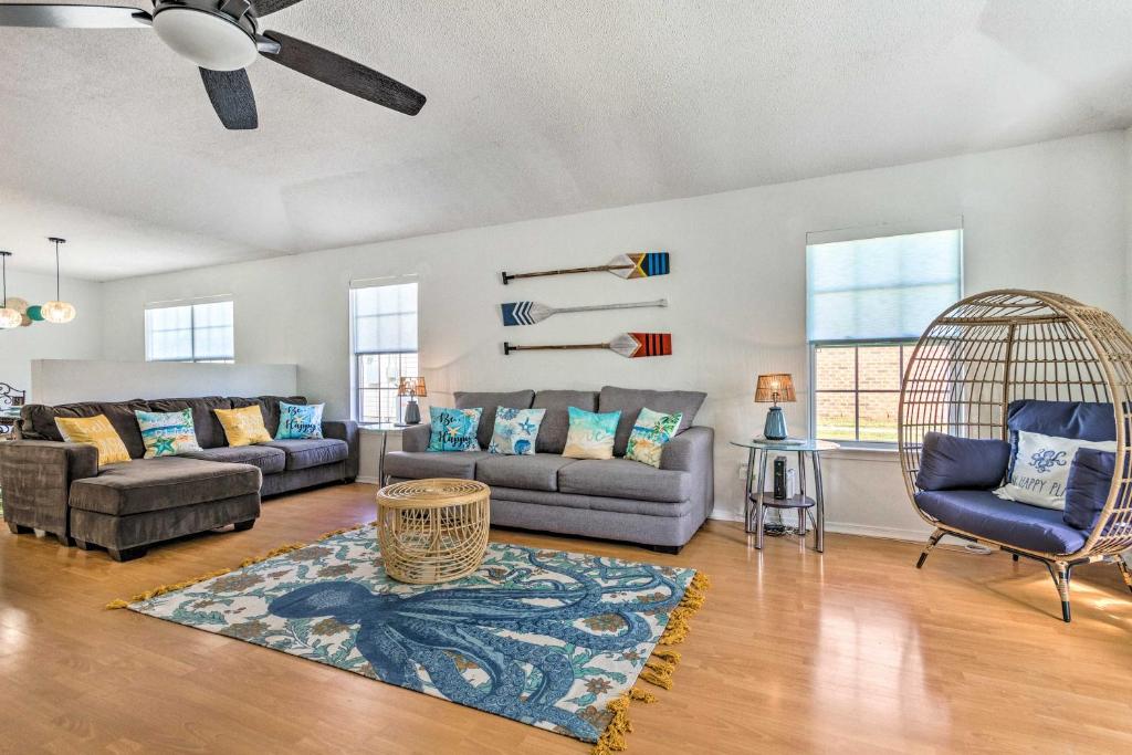 uma sala de estar com um sofá e cadeiras e uma ventoinha em Bright Pensacola Home with Yard about 6 Mi to Beach em Pensacola