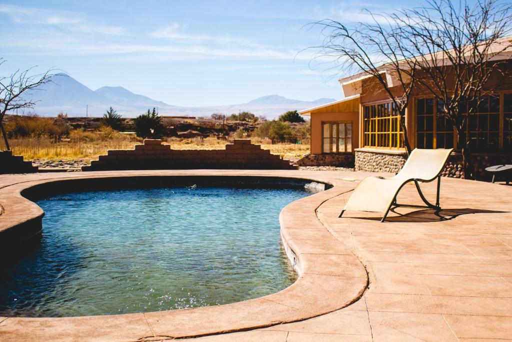 a chair sitting next to a swimming pool at Hotel Iorana Tolache in San Pedro de Atacama