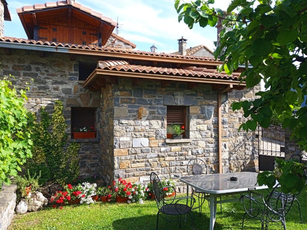 a stone house with a table in the yard at Casa La Tornagua in Biescas
