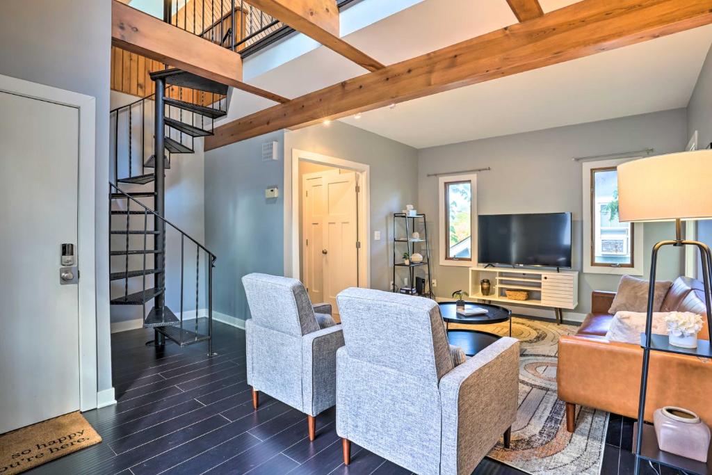 een woonkamer met 2 stoelen en een trap bij Minneapolis Townhome with Loft Less Than 3 Mi to Dtwn! in Minneapolis