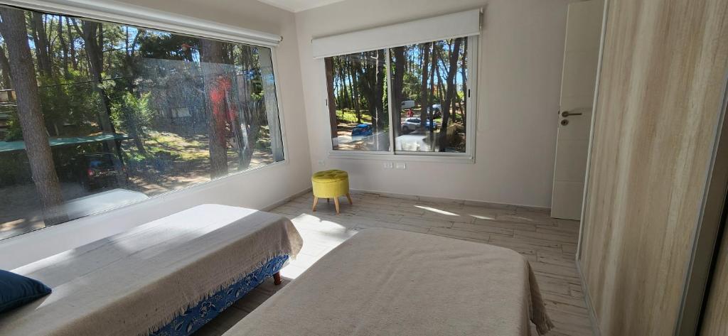 a bedroom with two beds and a large window at EL PINAR CASA DE PLAYA in Mar Azul