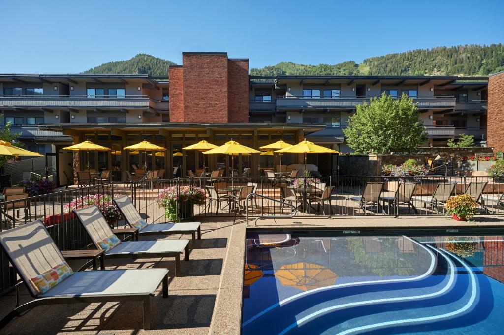 um hotel com uma piscina com cadeiras e guarda-sóis em Aspen Square Condominium Hotel em Aspen