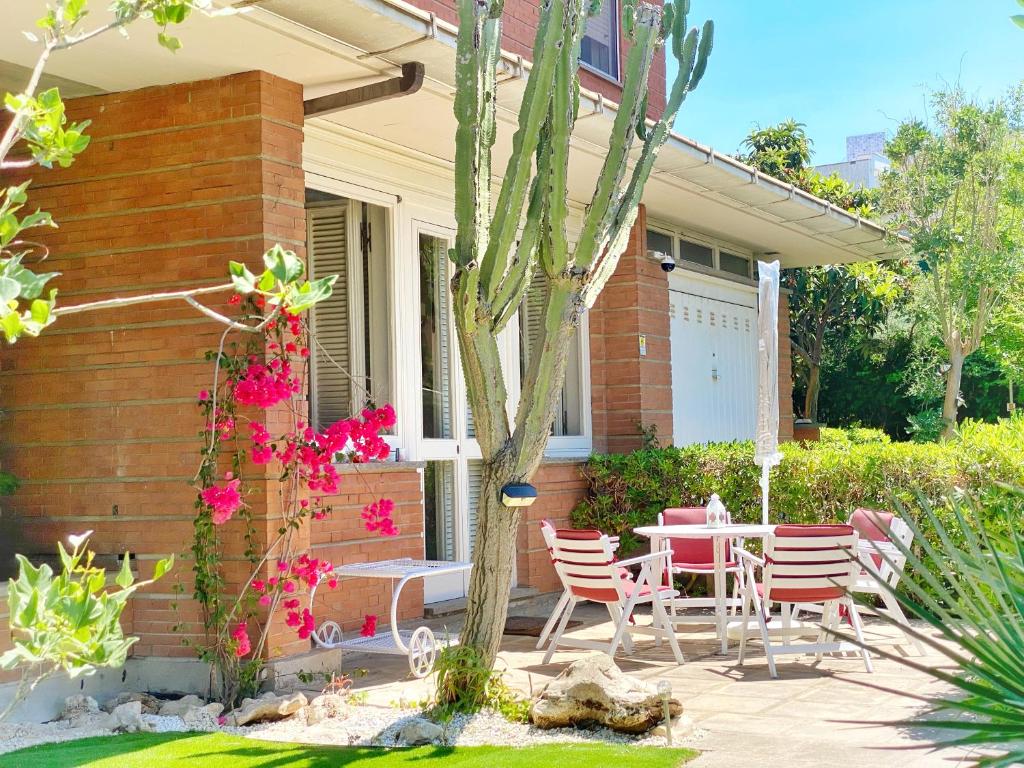 un patio con mesa y sillas frente a una casa en Villa Brando - Luxury Stay near Sabaudia and Pontine Beaches, en Latina
