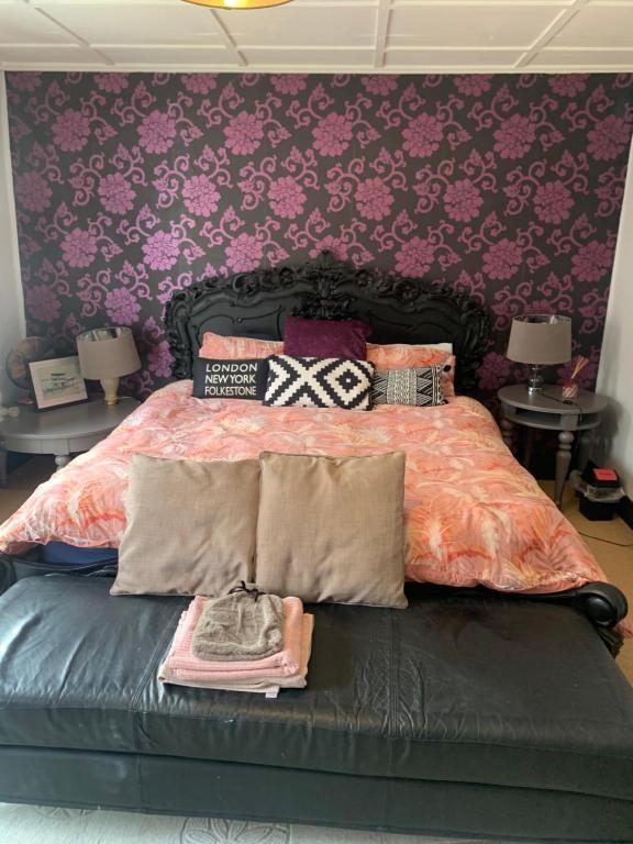 a bedroom with a bed with a purple wall at The Gatehouse in Folkestone