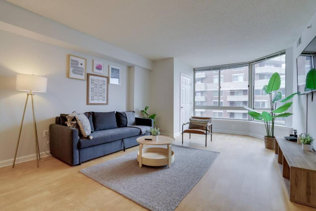 アーリントンにあるFascinating 1 Bedroom Condo At Ballston With Gymのリビングルーム(ソファ、テーブル付)