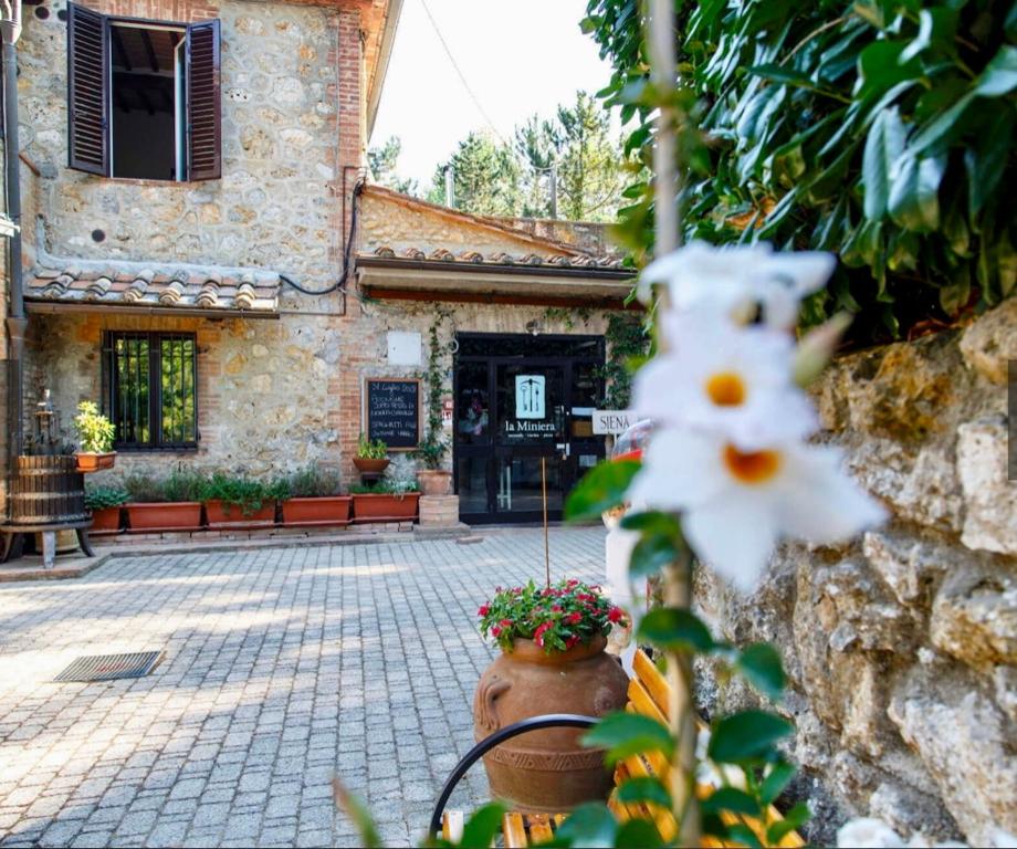 un edificio in pietra con un vaso di fiori davanti di Podere La Miniera Relax & Food a Siena