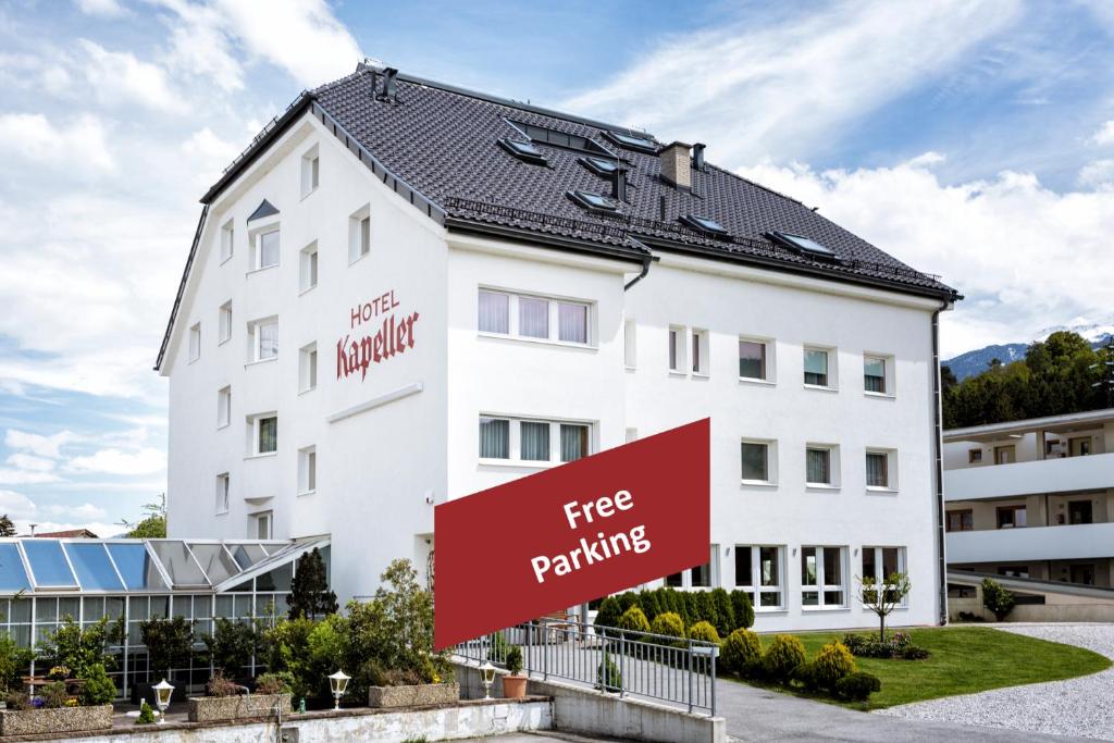 a white building with a free parking sign in front of it at Hotel Kapeller Innsbruck in Innsbruck