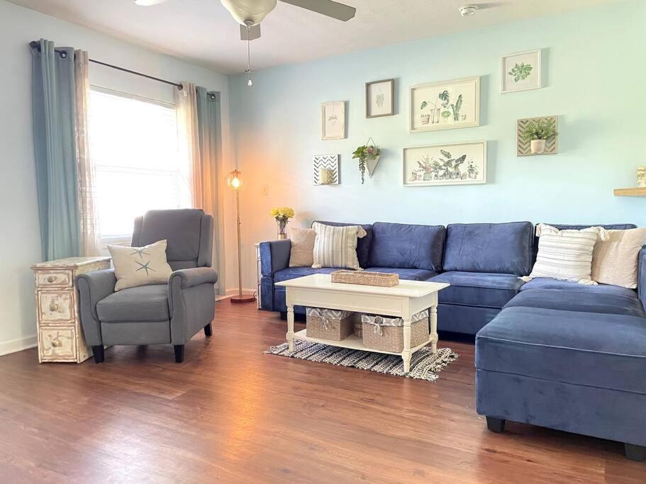 een woonkamer met een blauwe bank en 2 stoelen bij The Brick Beach House in Jacksonville Beach