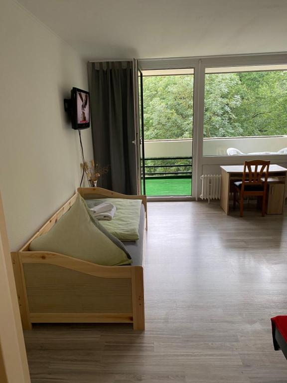 ハノーファーにあるApartment Hannover Messeのベッド、テーブル、窓が備わる客室です。