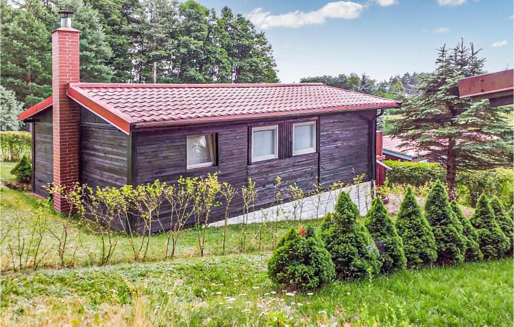 una pequeña casa en un patio con árboles y arbustos en Gorgeous Home In Biskupiec With Kitchen, en Wilimy