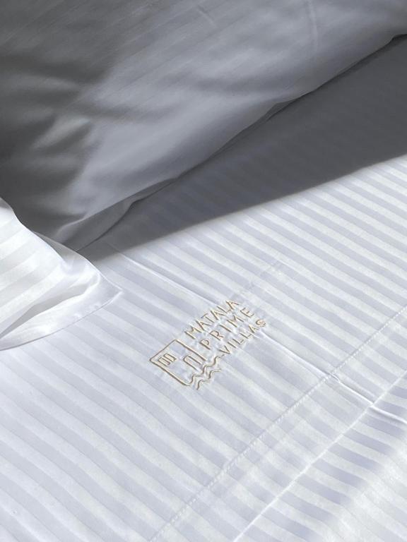 a white bed with a white comforter with the word sleep on it at Matala Prime Villas in Matala