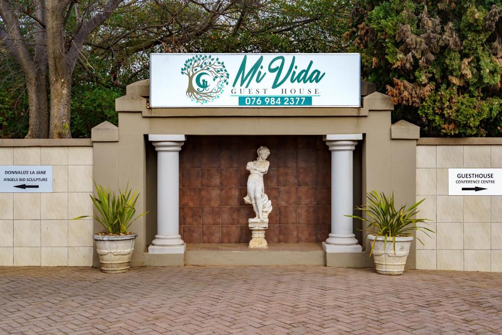 una señal para un museo con una estatua en una pared en Mi Vida Guesthouse, en Klerksdorp