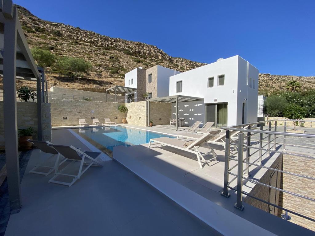 a pool on the roof of a house with chairs at Matala Prime Villas in Matala