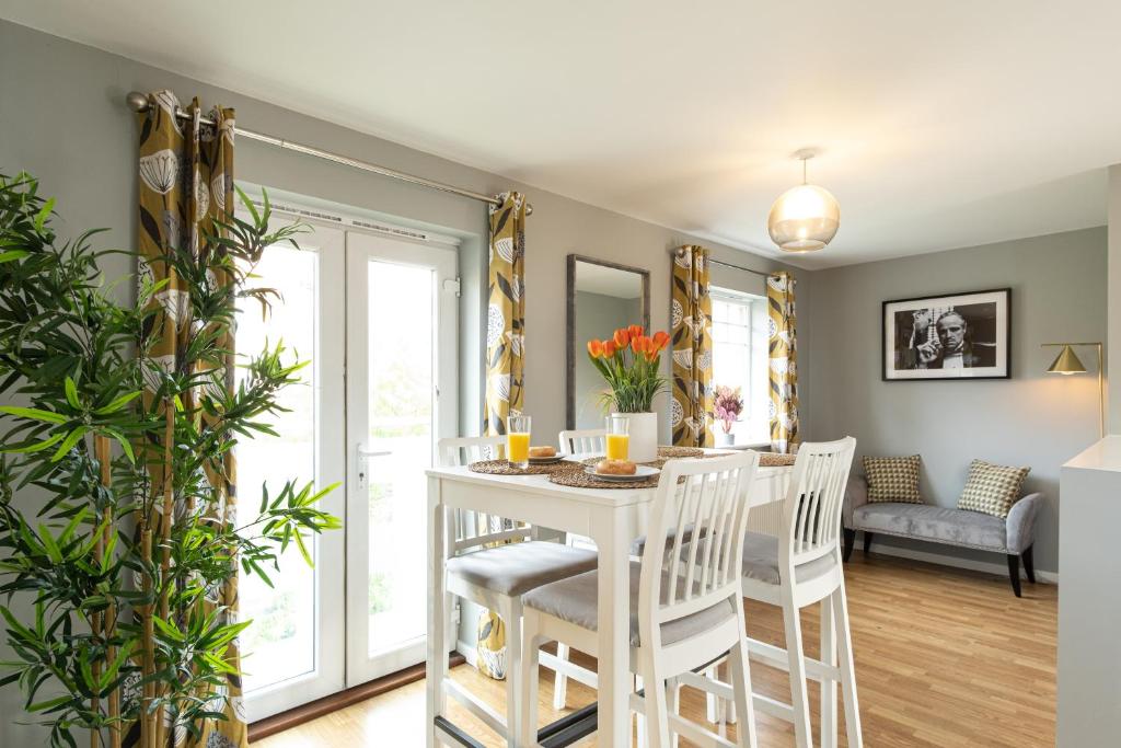 a kitchen and dining room with a white table and chairs at Wyllie Mews in Burton upon Trent