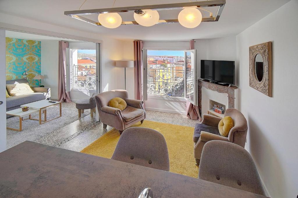 un salon avec une table et des chaises dans l'établissement Le Louvre Top Floor, à Cannes
