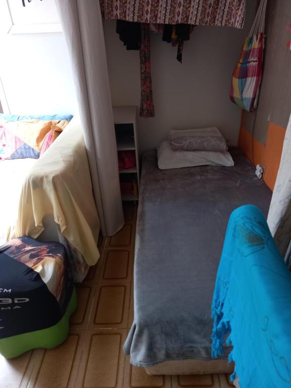 Cette petite chambre comprend 2 lits et une fenêtre. dans l'établissement Cama em dormitório misto, à Brasilia