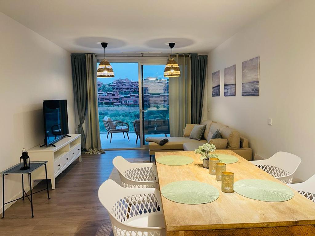 een woonkamer met een tafel en stoelen en een televisie bij Serenity sea view in Estepona