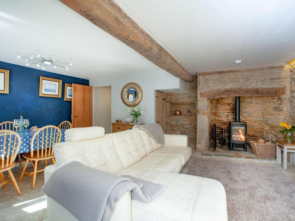 a living room with a white couch and a fireplace at The Barn House in Ugborough