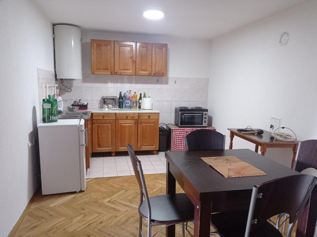 a kitchen with a table and a white refrigerator at Resetovac in Batočina