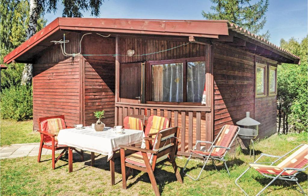 PojezierceにあるNice Home In Morag With 1 Bedroomsのキャビン前のテーブルと椅子