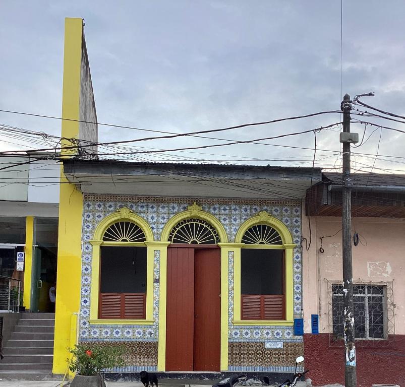un edificio colorido con una puerta roja en una calle en Casa Mafaldo en Iquitos