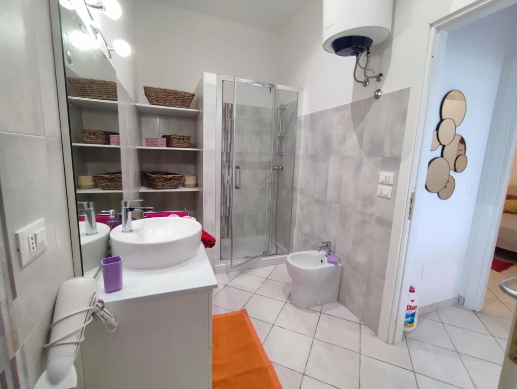 a white bathroom with a shower and a sink at Casa del Poggio Barone - Limone in Rodi