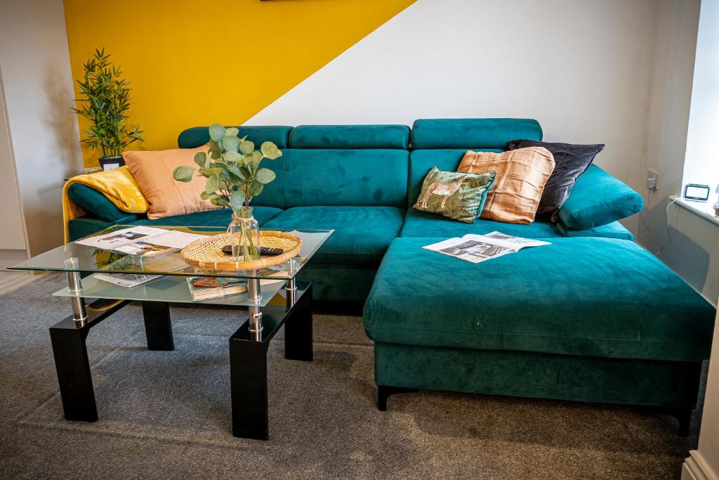 uma sala de estar com um sofá azul e uma mesa em Spacious 1-Bedroom Home with free private parking em Swansea