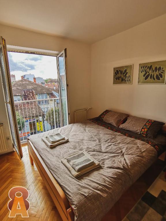 - une chambre avec un grand lit et une grande fenêtre dans l'établissement Apartman 8, à Valjevo