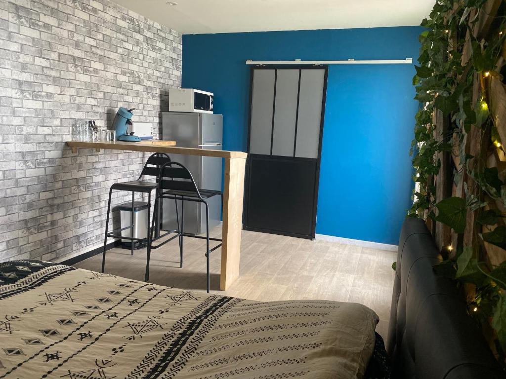a room with a bed and a blue wall at Chambre avec spa privatif in Amiens