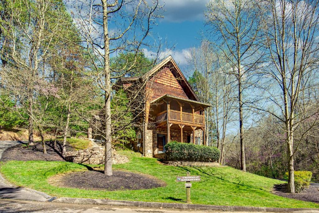 a house on a grassy hill with a tree at McCormack's Mill in Pigeon Forge