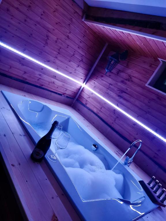 a bath tub with a bottle of wine in it at Tölgyes Menedék 2. in Noszvaj
