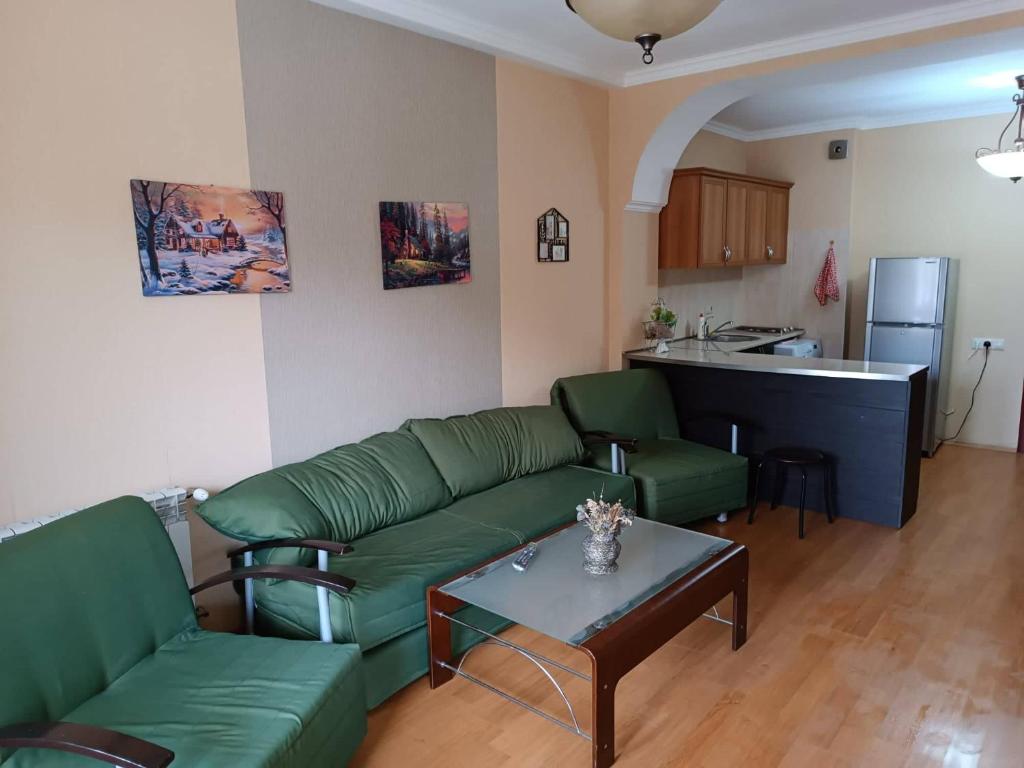a living room with a green couch and a table at Bakuriani-Otin in Bakuriani