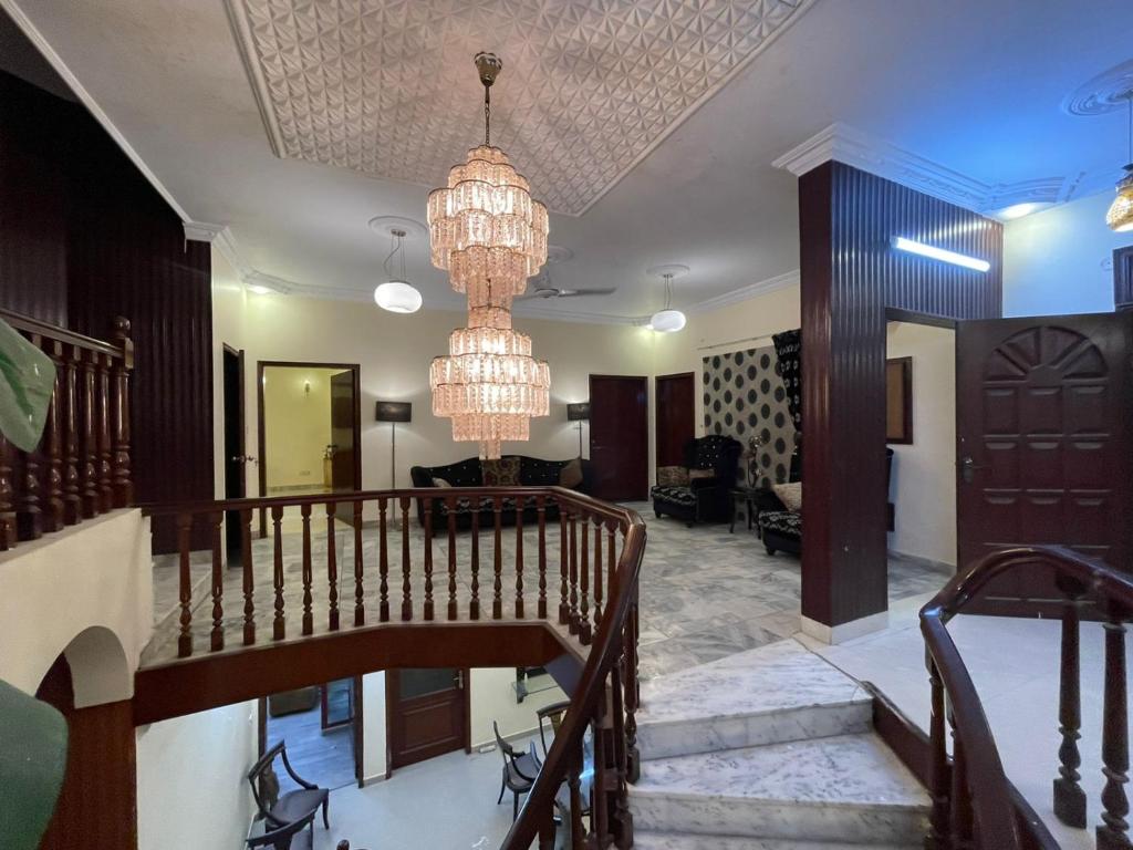a living room with a staircase and a chandelier at Hotel 12 O'clock in Karachi